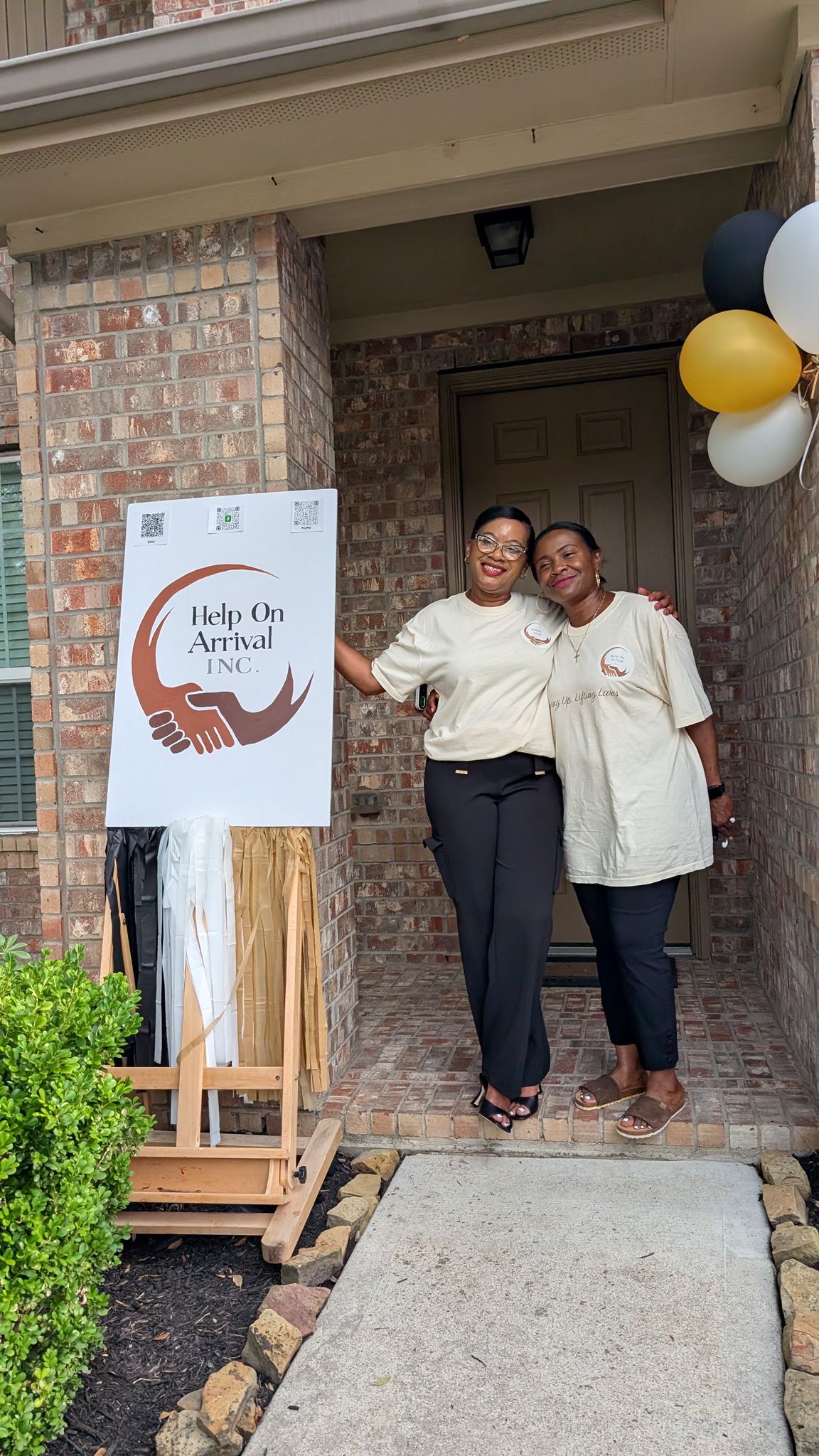 Two Help On Arrival team members photographed near the launch branding.
