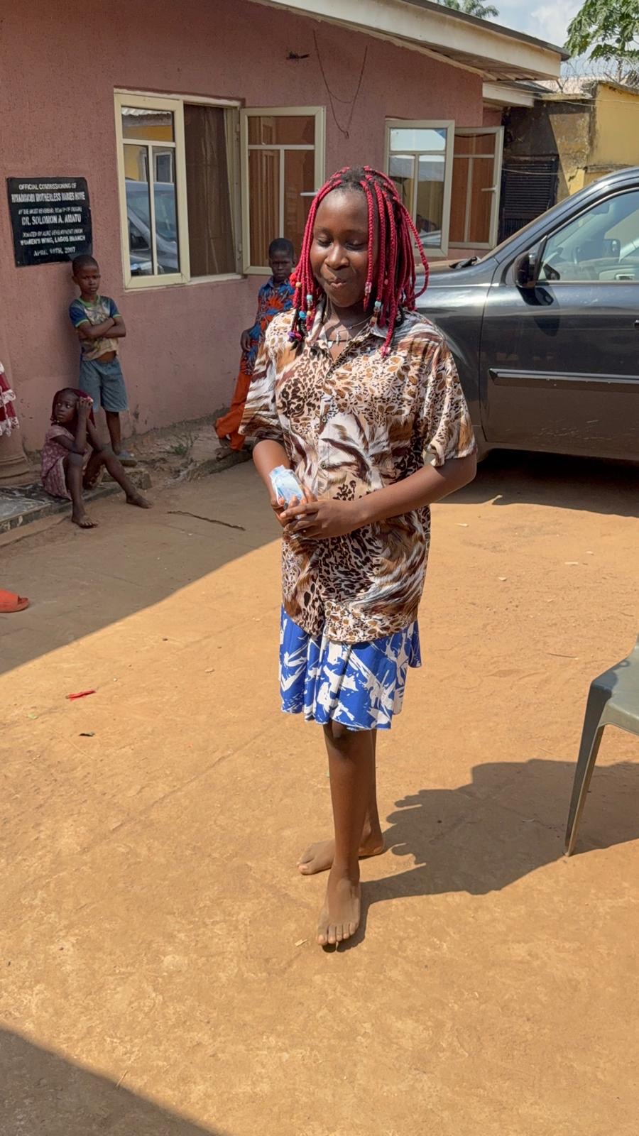 A girl standing outside the orphanage during the December event.