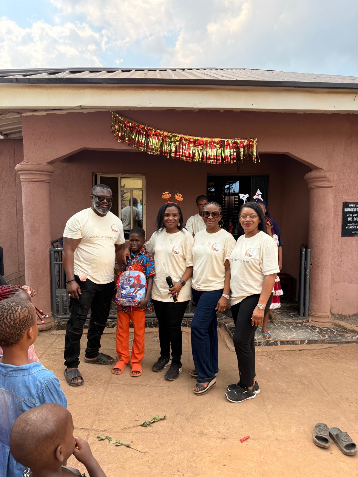 Help On Arrival team members posing with a child in front of the orphanage.