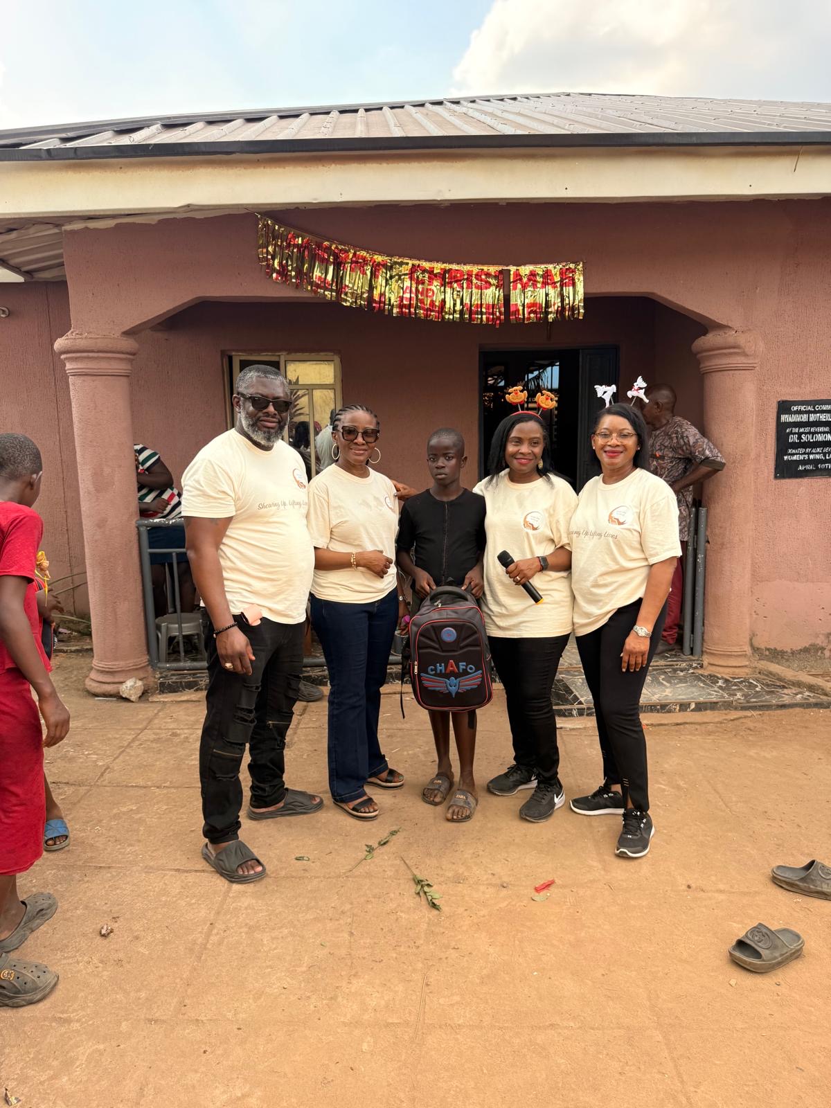 Help On Arrival team members standing with a child outside the orphanage.