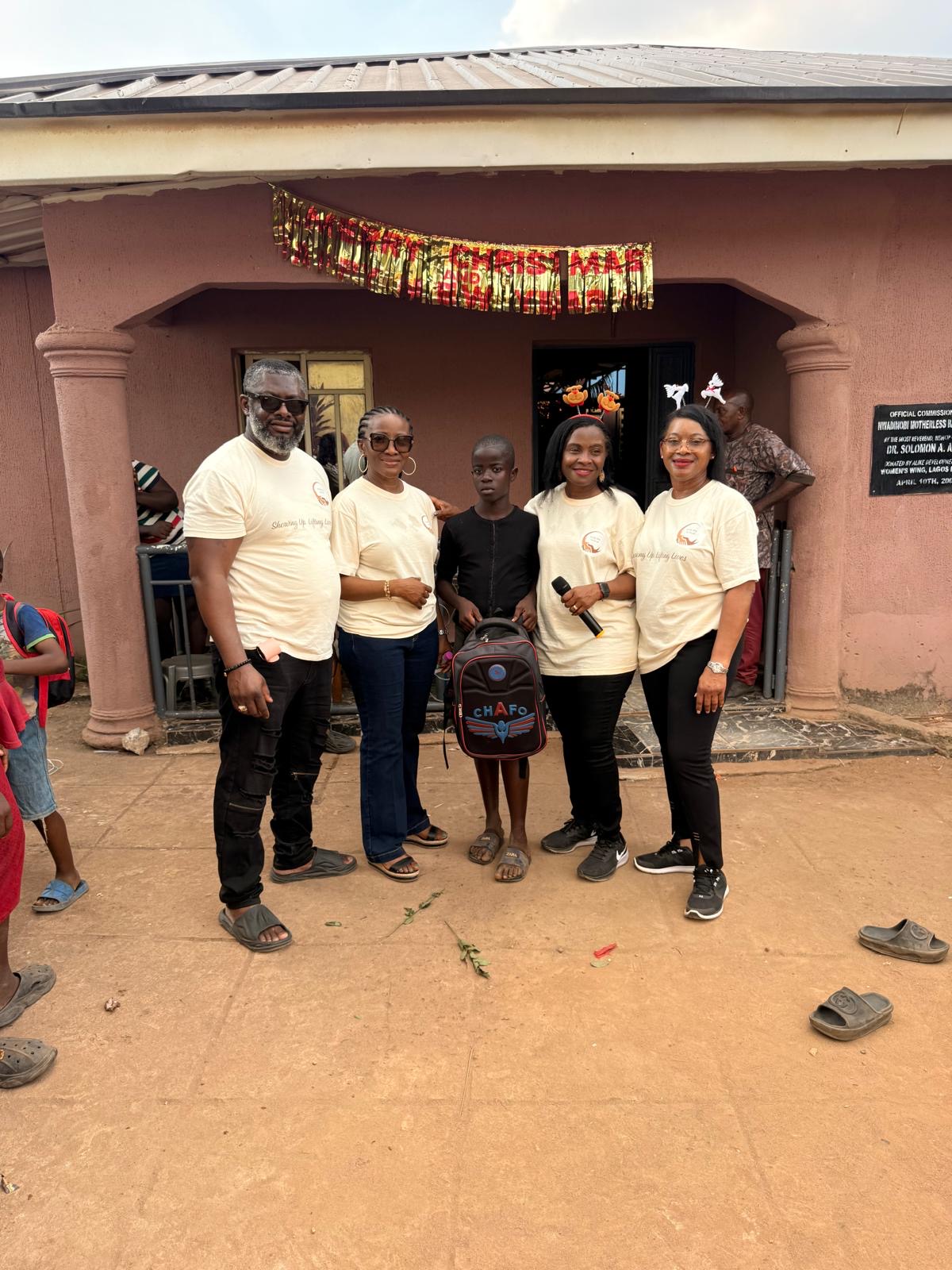 Help On Arrival team members standing with a child holding a backpack.