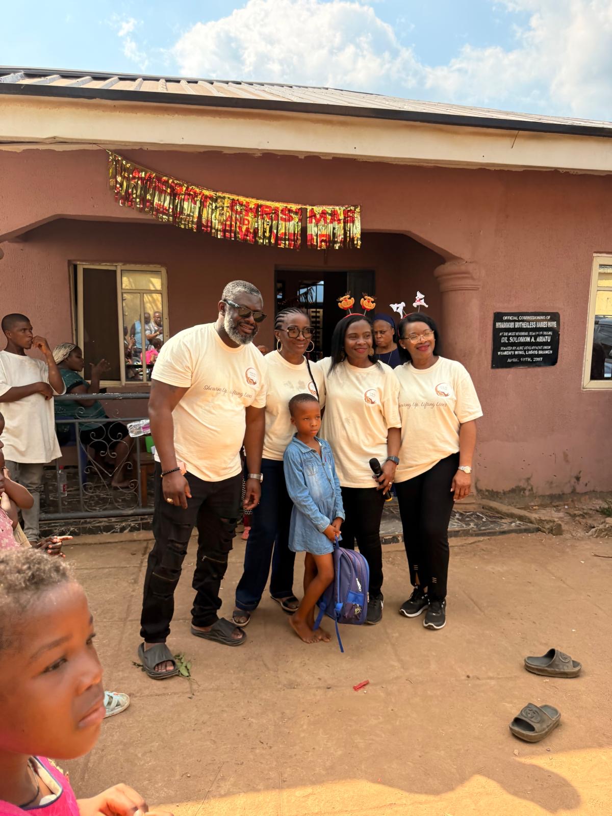 Help On Arrival team members standing with a child outside the orphanage.